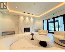 A living room with a fireplace and white furniture.