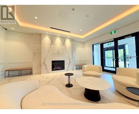 A living room with a fireplace and white furniture.