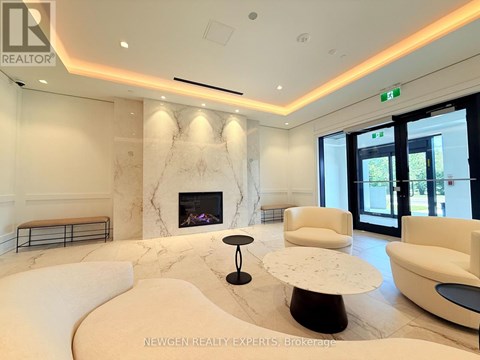 A living room with a fireplace and white furniture.