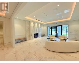 A spacious, well-lit room with a marble floor and a curved white bench.