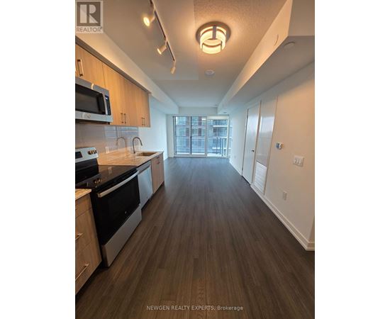 A kitchen with wood floors and a large window.
