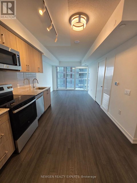 A kitchen with wood floors and a large window.