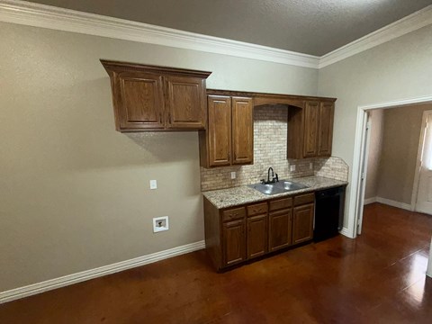 A kitchen with wooden cabinets and a white tile backsplash.