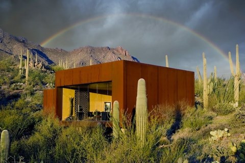 A modern house with a rainbow in the background.