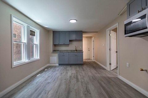 A kitchen with a grey countertop and cabinets.