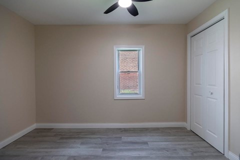 A room with a window and a ceiling fan.