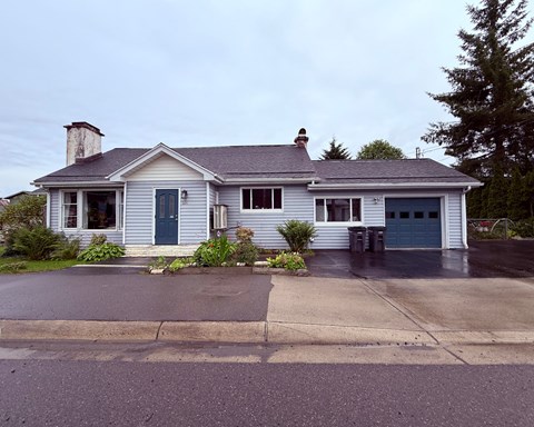A house with a grey roof and a blue door.