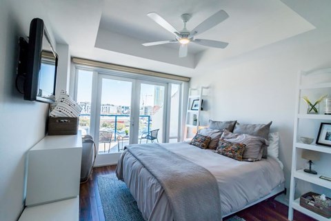 A bedroom with a large bed and a ceiling fan.