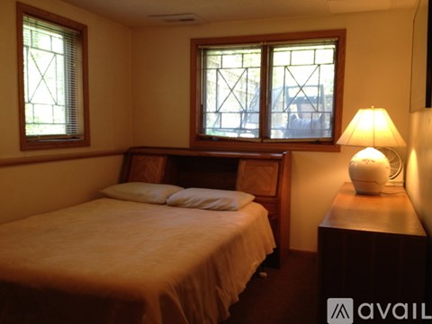 A bedroom with a bed, nightstand, and lamp.