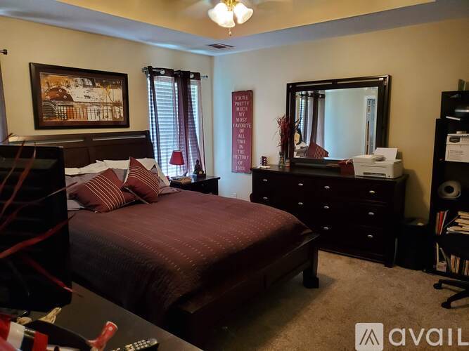 A bedroom with a large bed and a dresser with a mirror.
