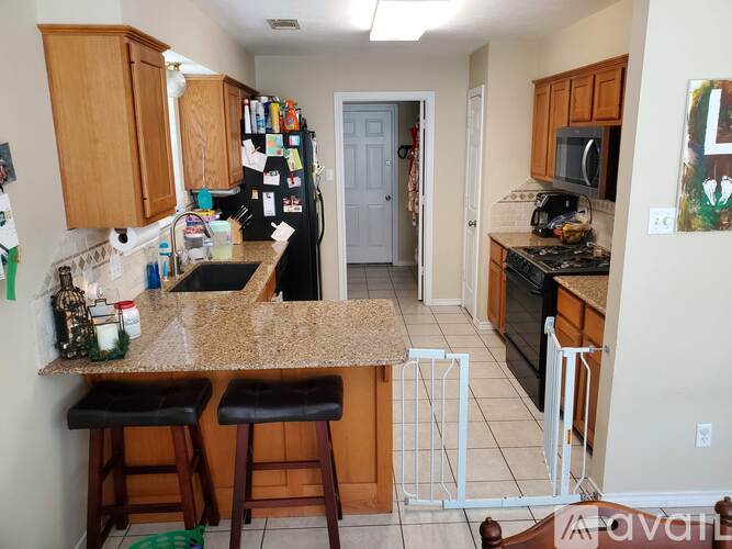A kitchen with a granite counter top and bar stools.