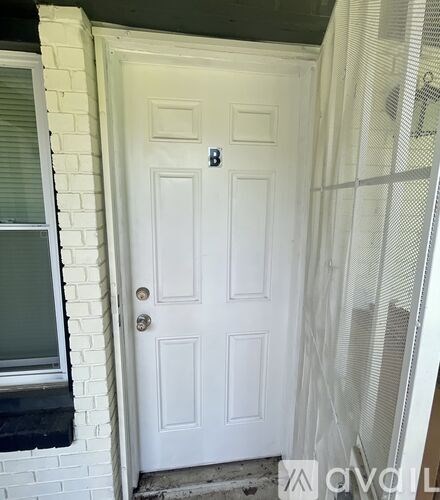A white door with a black handle and a letter B above it.