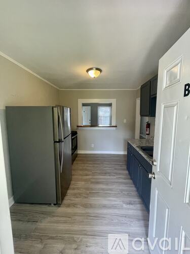 A kitchen with a refrigerator and cabinets.
