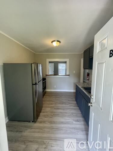 A kitchen with a refrigerator and cabinets.