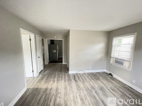 A room with wood flooring and a window on the right side.