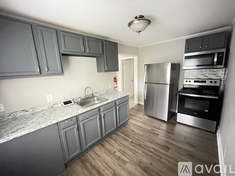 A kitchen with wooden floors and a marble counter top.