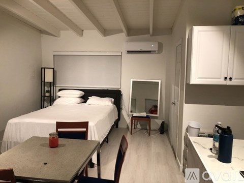 A bedroom with a bed, desk, and chair.