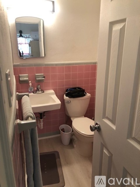 A bathroom with pink tiles and a white sink.