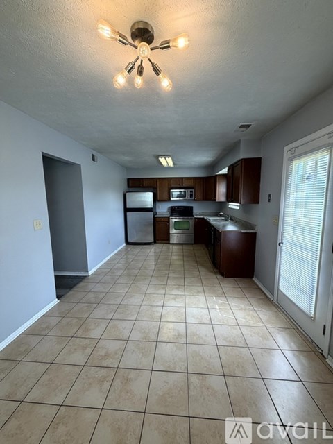 A kitchen with tile flooring and a ceiling fan.