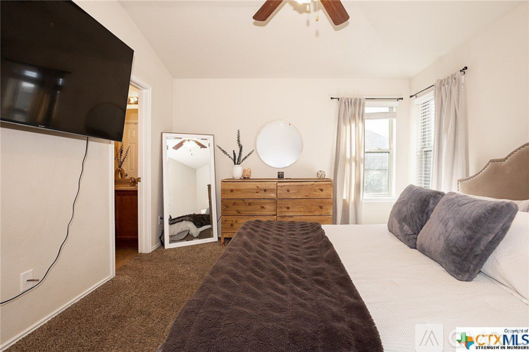 A bedroom with a bed, dresser, and mirror.