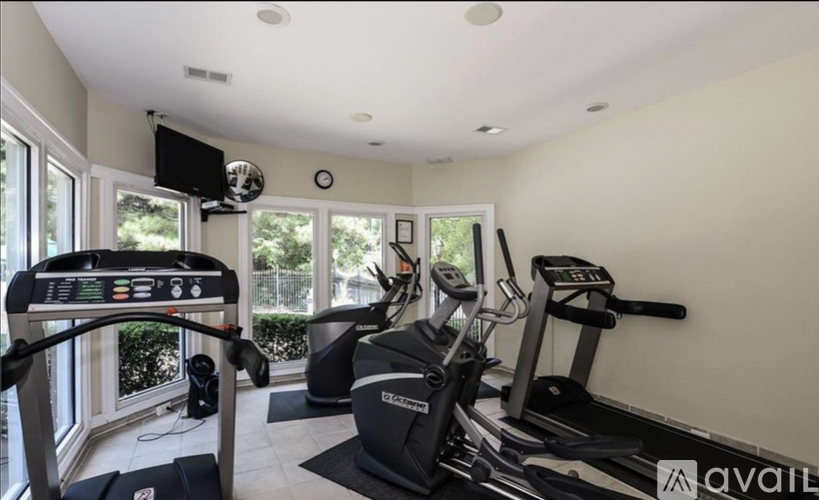 A home gym with treadmills and elliptical machines.