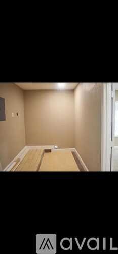 A room with a wooden table and a white wall.