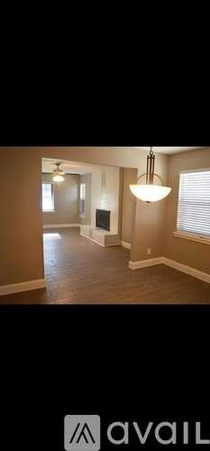 A living room with a fireplace and a hanging light fixture.