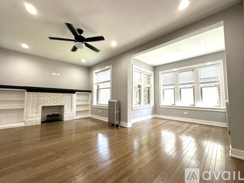 A spacious living room with wood flooring and a fireplace.