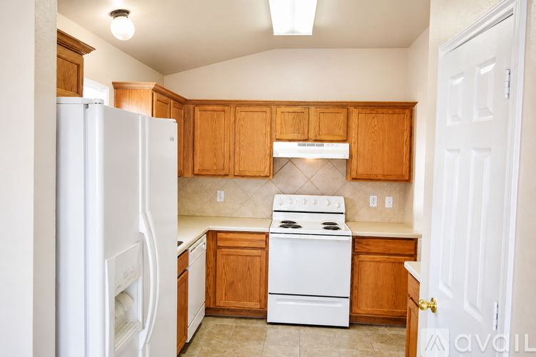 A kitchen with wooden cabinets and a white refrigerator.