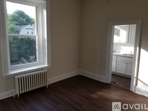 A room with a window and a radiator on the floor.