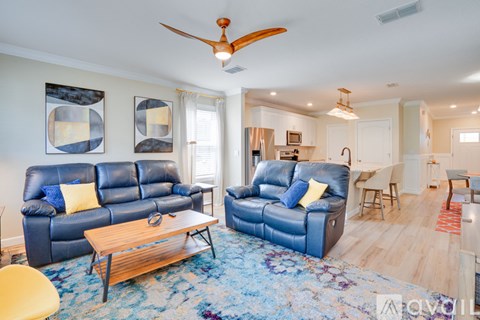 A living room with blue leather couches and a wooden coffee table.