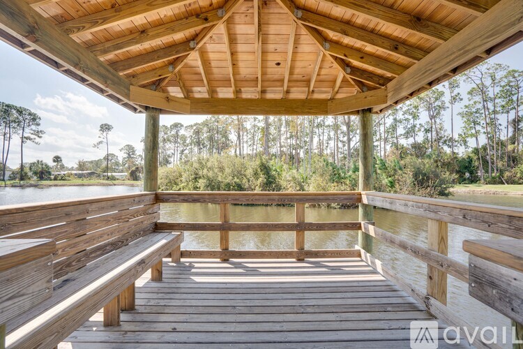 A wooden deck overlooking a body of water with trees in the background.