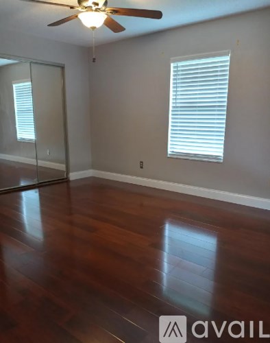 A room with wooden floors and a ceiling fan.