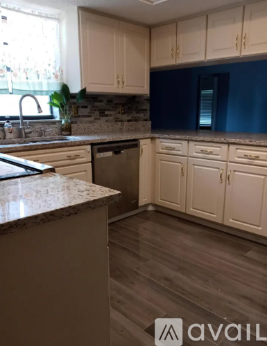 A kitchen with white cabinets and a granite countertop.