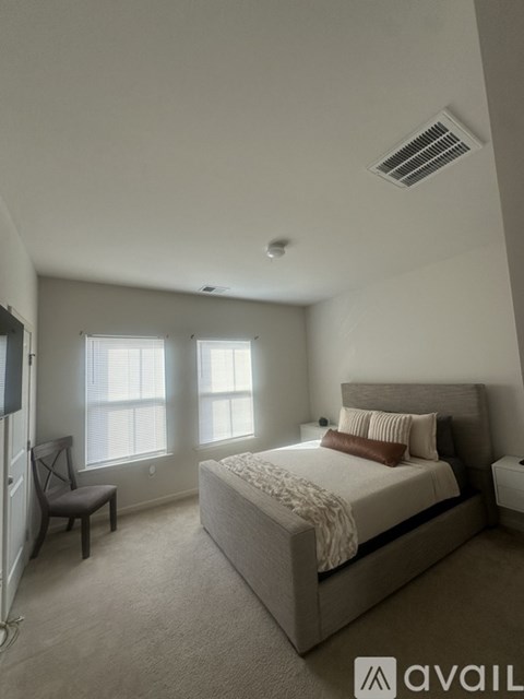 A bedroom with a large bed and a window.