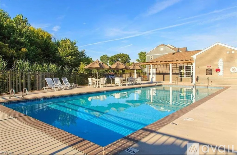 A large outdoor swimming pool with lounge chairs and umbrellas.