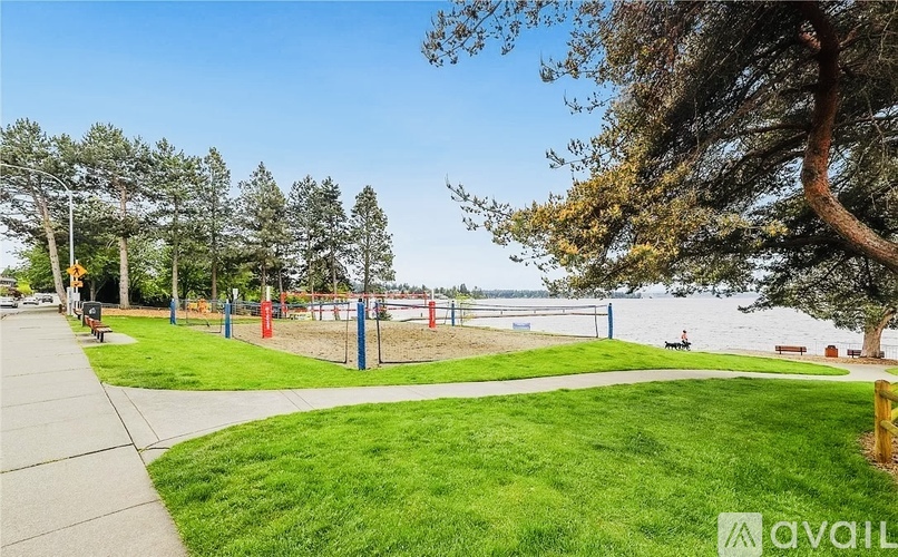 A park with a playground and a body of water in the background.