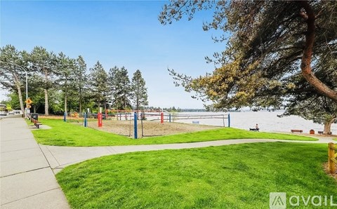 A park with a playground and a body of water in the background.