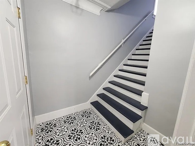 A staircase with a black and white tiled floor.