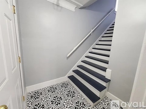 A staircase with a black and white tiled floor.
