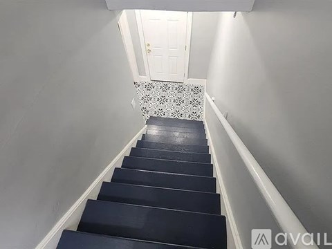 A staircase with black steps and a white railing.