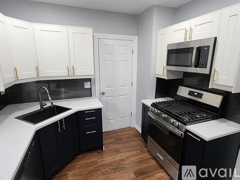 A kitchen with black and white cabinets and appliances.