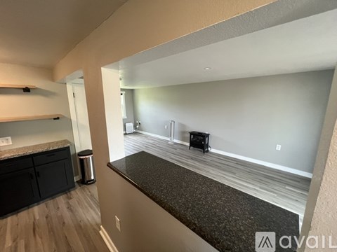 A living room with a black sofa and a grey carpet.
