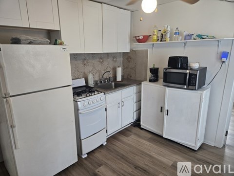 A kitchen with white appliances and cabinets.