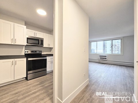 A kitchen with white cabinets and a black stove top oven.