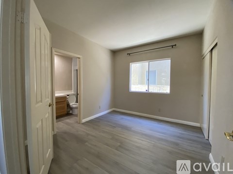 A room with a window and a door is available for rent.