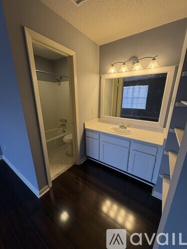 A bathroom with a sink, mirror, and shower.