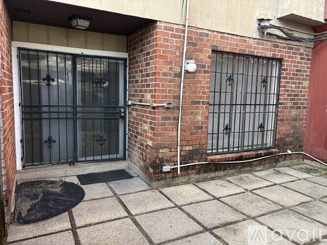 A brick building with a black gate and a red door.