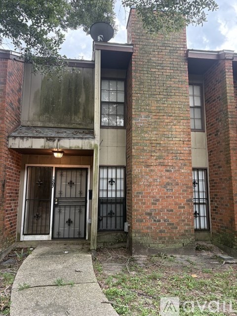 A brick building with a metal gate and a window with bars.