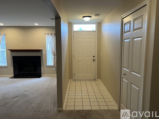 A room with a fireplace and a door leading to another room.